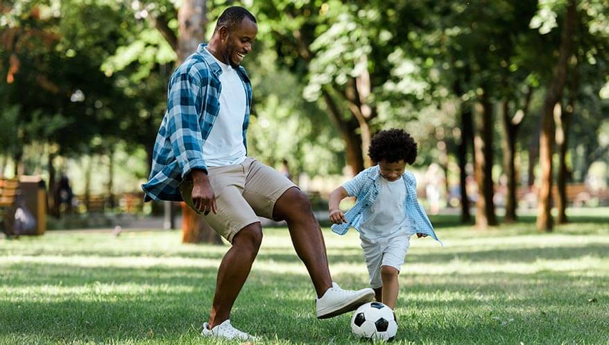 Dad and son playing soccer
